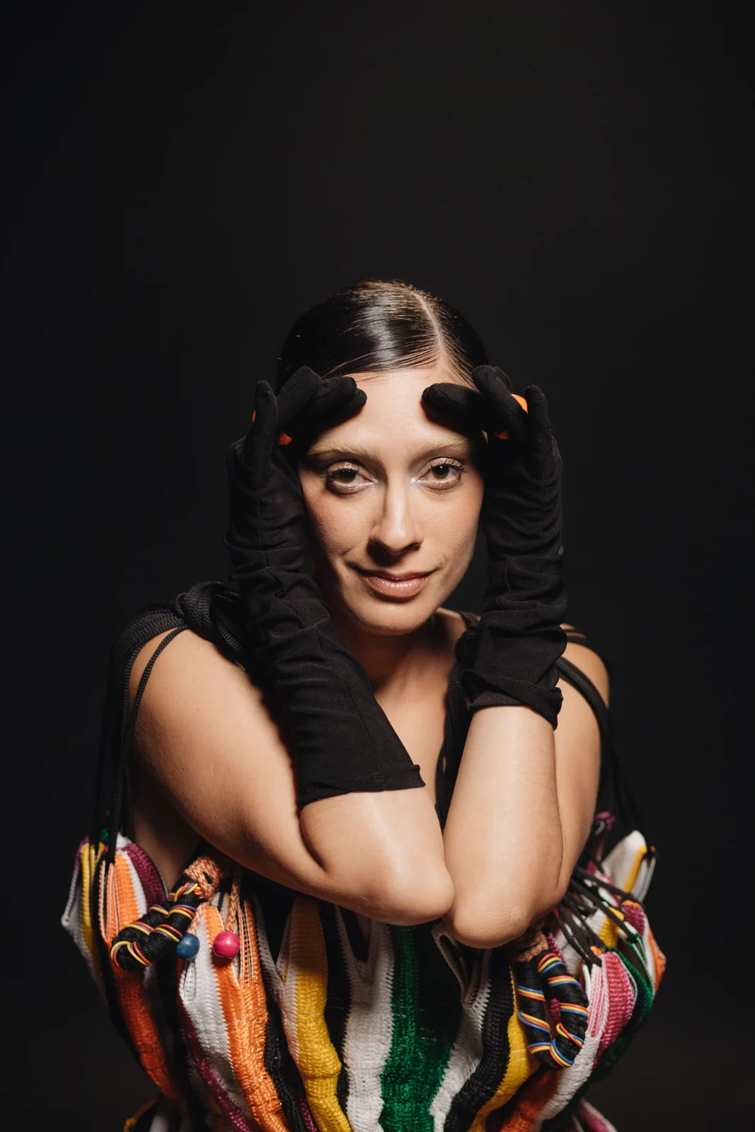 Juliana Linhares em retrato de estúdio, com as mãos junto ao rosto